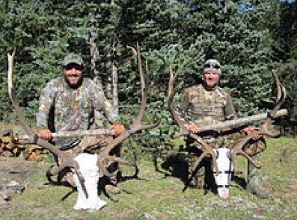 two hunters with elk antlers